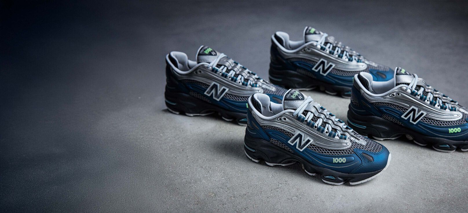 A group of four New Balance 1000 sneakers on a concrete floor 